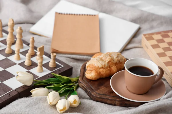 stock image Chess board with breakfast and tulips on plaid, closeup