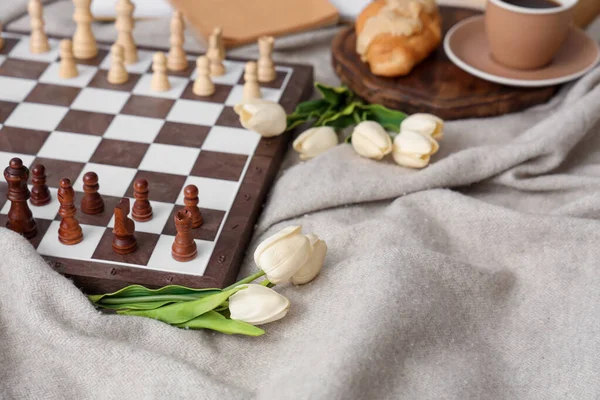 stock image Chess board with tulips on plaid, closeup