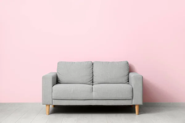 粉红墙边舒适的灰色沙发 — 图库照片