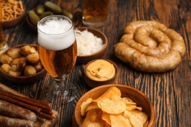 Bir bardak soğuk bira ve ahşap arka planda farklı atıştırmalıklar. Ekim Festivali Kutlaması