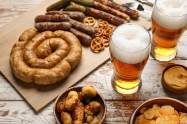 Soğuk bira bardakları ve hafif ahşap arka planda farklı atıştırmalıklar. Ekim Festivali Kutlaması