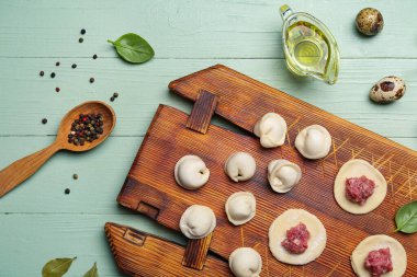 Yeşil ahşap arka planda pişmemiş hamur tatlısı olan tahta.