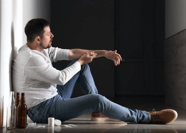 Erkek uyuşturucu bağımlısı koridorda iğne yapıyor.