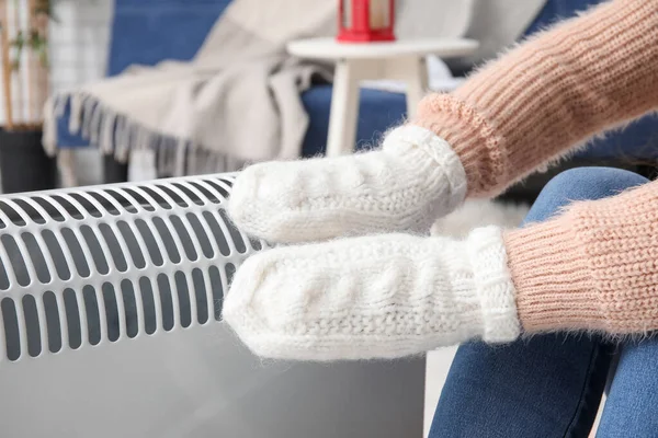 stock image Woman warming hands in mittens near radiator at home, closeup