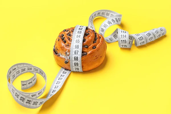 Tasty Chocolate Bun Measuring Tape Yellow Background Closeup Diet Concept — Stock Photo, Image