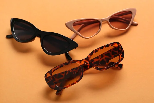 Verschiedene Stylische Brillen Auf Orangefarbenem Hintergrund Nahaufnahme — Stockfoto