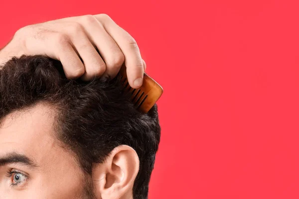 Young Brunette Man Combing Hair Red Background Closeup — Stock Photo, Image