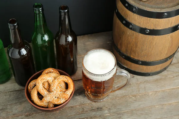 Krug Mit Kaltem Bier Flaschen Brezeln Und Holzfässern Auf Dem — Stockfoto