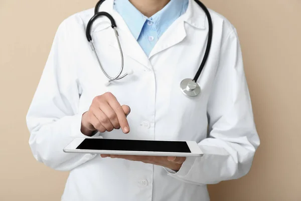 Médica Com Estetoscópio Usando Computador Tablet Fundo Bege — Fotografia de Stock