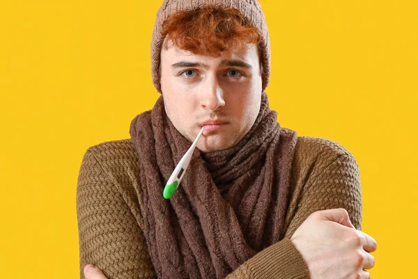 Homem Jovem Medindo Temperatura Com Termômetro Fundo Amarelo Close — Fotografia de Stock