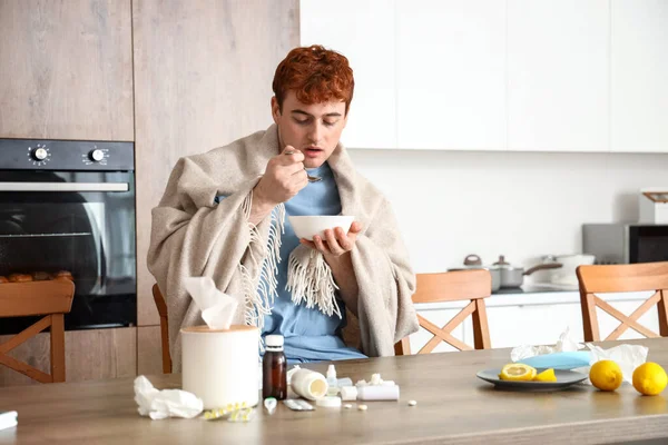 若い男は台所でスープを食べる — ストック写真