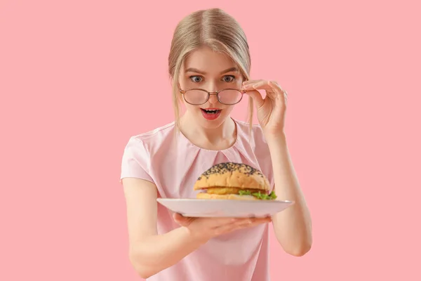 Shocked Young Woman Tasty Burger Pink Background — Stock Photo, Image