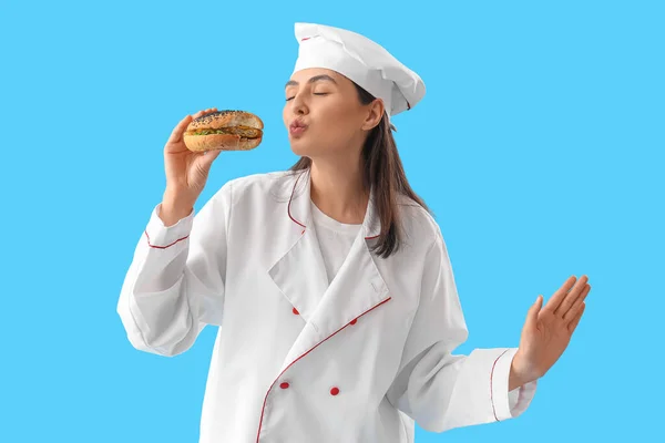 Female Chef Tasty Burger Blowing Kiss Blue Background — Stock Photo, Image