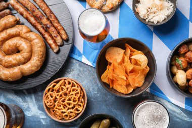 Soğuk bira bardakları ve mavi arka planda farklı atıştırmalıklar. Ekim Festivali Kutlaması