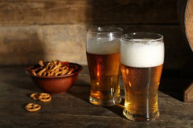 Ahşap zemin üzerinde çubuk kraker olan soğuk bira bardakları yakın plan.