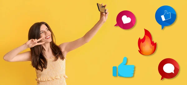 年轻女性在黄色背景下的自拍和社交网络反应 — 图库照片