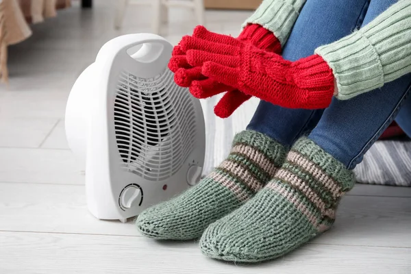 Vrouw Verwarmende Handen Handschoenen Buurt Van Elektrische Ventilator Verwarming Thuis — Stockfoto