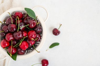 Beyaz arka planda tatlı kirazlı Colander