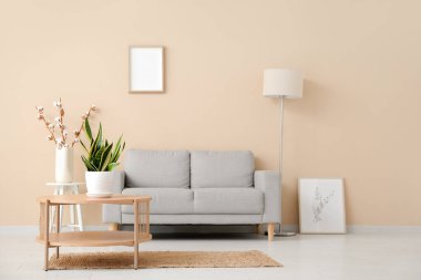 Oturma odasının içinde kanepe ve masa var.