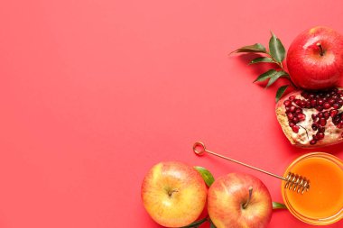 Kırmızı zemin üzerinde Rosh Hashanah kutlaması (Yahudi Yeni Yılı) için bal, nar ve elma kavanozu