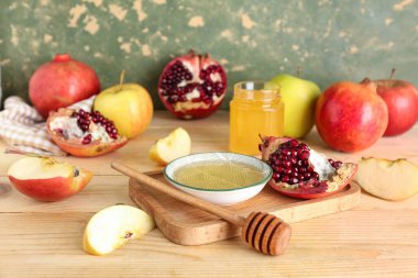 Tahta masada, Rosh Hashanah kutlaması (Yahudi Yeni Yılı) için bir kase bal, nar ve elmayla birlikte.