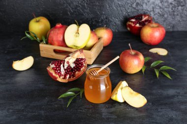 Rosh Hashanah kutlaması için kavanoz bal, nar ve elma (Yahudi Yeni Yılı) siyah masada