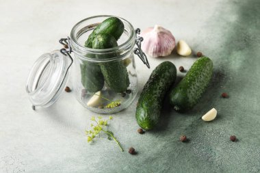 Arkaplanda taze salatalık korunması için kavanoz.