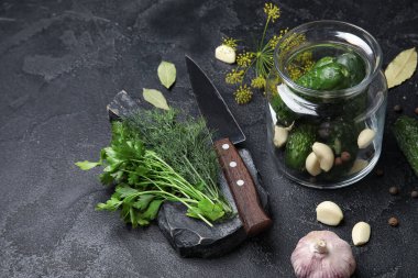 Siyah arka planda korunması için taze salatalıklı kavanoz.