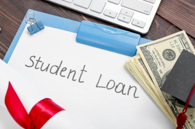Diploma, dolar banknotları, mezuniyet şapkası ve ahşap arka planda STUDENT kredisi olan kağıt kağıtlar.