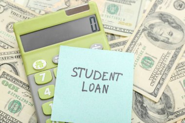 ÖĞRETMENE kredisiyle yapışkan not ve dolar banknotları üzerinde hesap makinesi, yakın plan