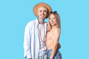 Mavi arka planda yaz kıyafetleri içinde genç bir çift.