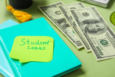 Yeşil arkaplan üzerine ders kredileri, defter ve dolar banknotları içeren yapışkan bir not