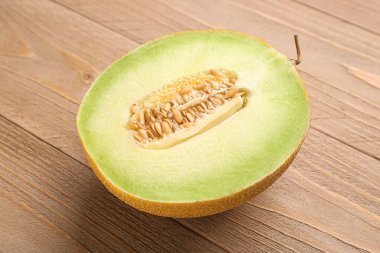 Ahşap arka planda tatlı kavunun yarısı
