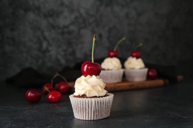 Siyah arka planda vişneli kek.