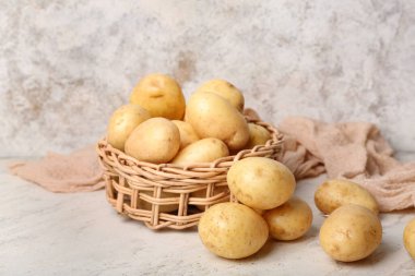 Beyaz masada çiğ patatesli hasır kase.