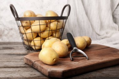 Tahta masada çiğ patates ve sepet.
