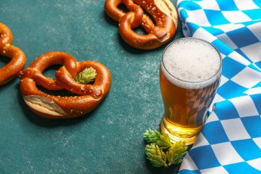 Bavyera bayrağı, biralı bardak ve mavi arka planda kraker.