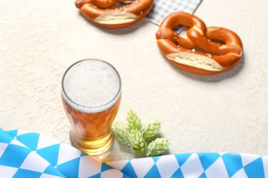 Bavyera bayrağı, bira bardağı ve beyaz arka planda krakerler.