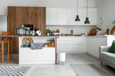 Ahşap masadaki modern aletlerle aydınlık mutfağın içinde.