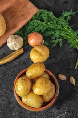 Siyah arka planda çiğ patates kasesi.