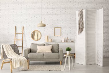 Modern oturma odası. Gri kanepe, koltuk ve katlanmış ekran.