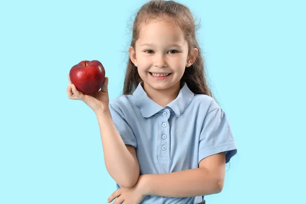 Mała Uczennica Jabłkiem Jasnoniebieskim Tle — Zdjęcie stockowe