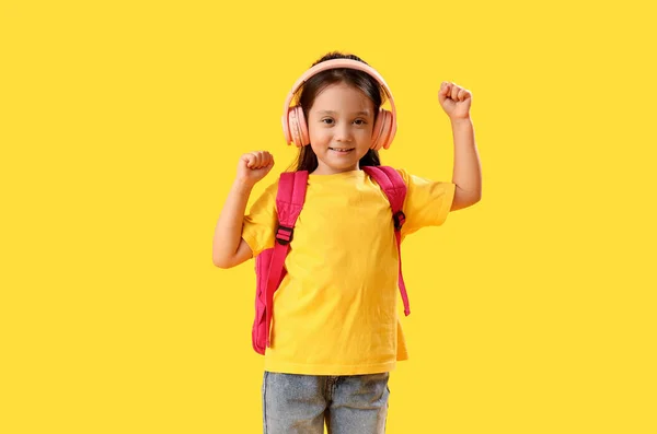 Маленька Школярка Слухає Музику Жовтому Фоні — стокове фото
