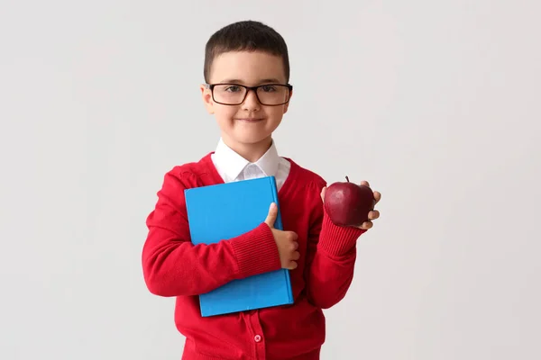 Kleiner Schuljunge Mit Buch Und Apfel Auf Grauem Hintergrund — Stockfoto