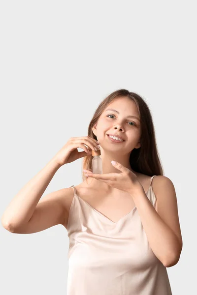 Mooie Jonge Vrouw Met Cosmetische Olie Lichte Achtergrond — Stockfoto