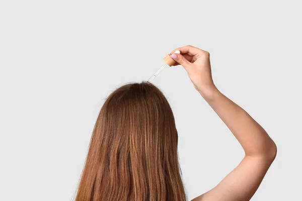 Genç Bir Kadın Arka Planda Arka Planda Saç Bakımında Kozmetik — Stok fotoğraf