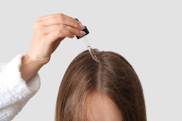 Jeune Femme Utilisant Huile Cosmétique Pour Traitement Des Cheveux Sur — Photo