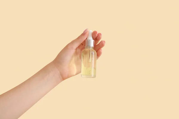 Hand Kvinna Med Flaska Kosmetisk Olja Beige Bakgrund — Stockfoto