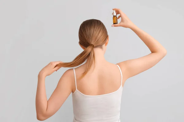 Young Woman Cosmetic Oil Hair Treatment Light Background Back View — Stock Photo, Image
