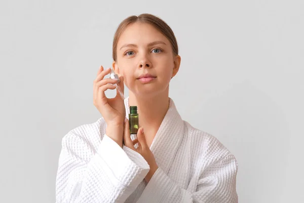 Söt Ung Kvinna Med Kosmetisk Olja Ljus Bakgrund — Stockfoto